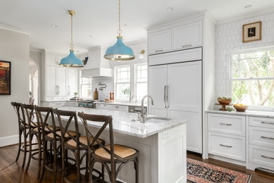 Inspiration for a large coastal galley dark wood floor and brown floor eat-in kitchen remodel in Atlanta with an undermount sink, shaker cabinets, white cabinets, quartzite countertops, white backsplash, marble backsplash, paneled appliances, an island and white countertops
