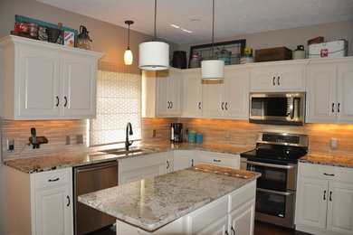 Example of a mid-sized trendy u-shaped dark wood floor and brown floor enclosed kitchen design in Omaha with an undermount sink, raised-panel cabinets, white cabinets, granite countertops, beige backsplash, ceramic backsplash, black appliances and an island