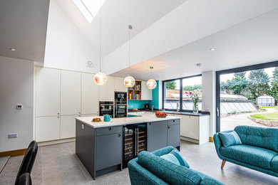 Design ideas for an expansive modern l-shaped open plan kitchen in Other with flat-panel cabinets, white cabinets, quartz worktops, an island, grey floors, white worktops and a vaulted ceiling.