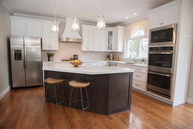 Eat-in kitchen - large modern l-shaped eat-in kitchen idea in St Louis with recessed-panel cabinets, white cabinets and an island
