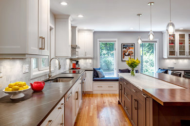 Large transitional l-shaped medium tone wood floor and brown floor kitchen photo in Bridgeport with a single-bowl sink, white cabinets, marble countertops, white backsplash, marble backsplash, stainless steel appliances, white countertops, beaded inset cabinets and an island