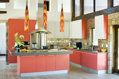 Bild på ett stort funkis kök, med en undermonterad diskho, släta luckor, röda skåp, bänkskiva i kvarts, flerfärgad stänkskydd, stänkskydd i glaskakel, rostfria vitvaror, ljust trägolv och en köksö