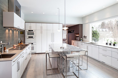 Inspiration for a large modern medium tone wood floor kitchen pantry remodel in Philadelphia with flat-panel cabinets, white cabinets, concrete countertops, porcelain backsplash, white appliances, a single-bowl sink, green backsplash and an island