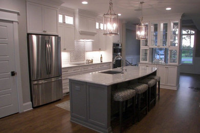 Imagen de cocina lineal tradicional renovada grande con armarios con paneles lisos, puertas de armario blancas y encimera de cuarcita