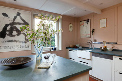 サセックスにあるトランジショナルスタイルのおしゃれなアイランドキッチン (エプロンフロントシンク、フラットパネル扉のキャビネット、白いキャビネット、赤い床、青いキッチンカウンター) の写真