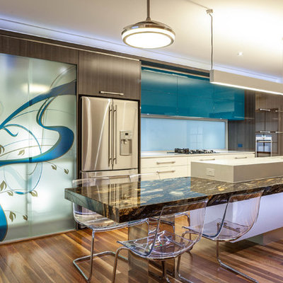 Mid-sized trendy galley medium tone wood floor eat-in kitchen photo in Brisbane with stainless steel appliances, flat-panel cabinets, marble countertops and an island