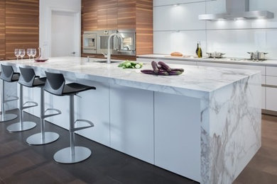 Inspiration for a contemporary kitchen remodel in Vancouver with an integrated sink, flat-panel cabinets, medium tone wood cabinets, marble countertops, white backsplash, glass tile backsplash, stainless steel appliances and an island