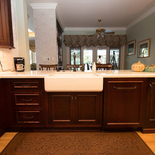 Mid-sized traditional kitchen designs - Inspiration for a mid-sized timeless u-shaped porcelain tile and brown floor kitchen remodel in Other with a farmhouse sink, recessed-panel cabinets, dark wood cabinets, quartz countertops, gray backsplash, mosaic tile backsplash, paneled appliances and white countertops
