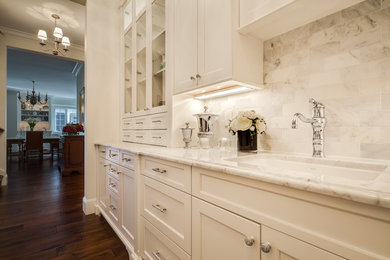 Inspiration for a timeless single-wall dark wood floor kitchen pantry remodel with an undermount sink, recessed-panel cabinets, white cabinets, marble countertops, white backsplash, stone tile backsplash, paneled appliances and no island