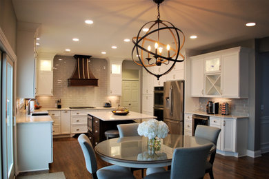 Eat-in kitchen - large transitional u-shaped medium tone wood floor and brown floor eat-in kitchen idea in Cleveland with a farmhouse sink, shaker cabinets, white cabinets, quartz countertops, gray backsplash, glass tile backsplash, stainless steel appliances, an island and white countertops