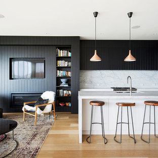 Design ideas for a contemporary l-shaped open plan kitchen in Sydney with an undermount sink, beaded inset cabinets, black cabinets, white splashback, stainless steel appliances, light hardwood floors and with island.