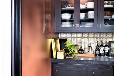 Aménagement d'une cuisine avec un placard à porte vitrée, des portes de placard noires et une crédence en mosaïque.
