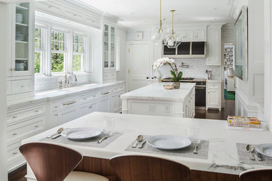Inspiration for a large timeless l-shaped dark wood floor eat-in kitchen remodel in New York with recessed-panel cabinets, white cabinets, white backsplash, black appliances, an island, a single-bowl sink, marble countertops and subway tile backsplash