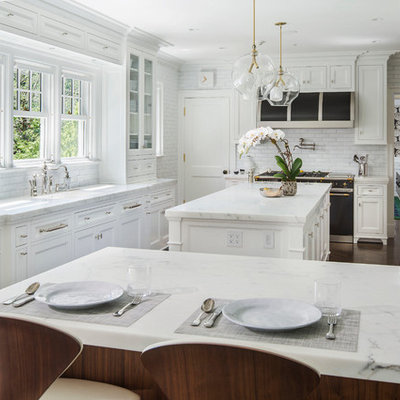 Inspiration for a large timeless l-shaped dark wood floor eat-in kitchen remodel in New York with recessed-panel cabinets, white cabinets, white backsplash, black appliances, an island, a single-bowl sink, marble countertops and subway tile backsplash