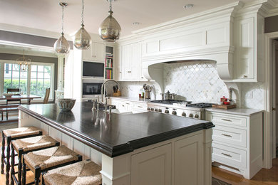 Idéer för ett mellanstort kök och matrum, med en nedsänkt diskho, vita skåp, träbänkskiva, vitt stänkskydd, stänkskydd i marmor, rostfria vitvaror, mellanmörkt trägolv, en köksö och brunt golv