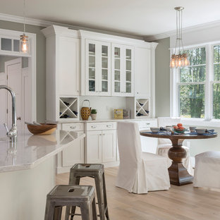 Farmhouse eat-in kitchen ideas - Eat-in kitchen - country light wood floor eat-in kitchen idea in Providence with a farmhouse sink, shaker cabinets, white cabinets and an island