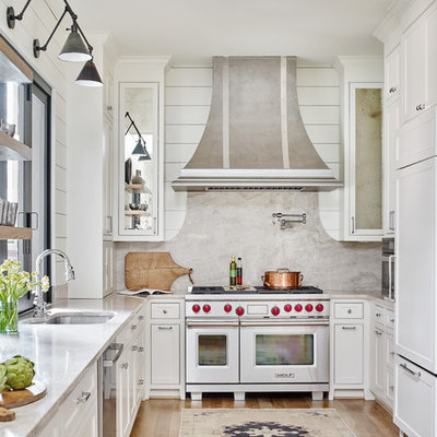 Inspiration for a mid-sized cottage u-shaped medium tone wood floor and brown floor eat-in kitchen remodel in Atlanta with an undermount sink, white cabinets, stone slab backsplash, recessed-panel cabinets, marble countertops, white backsplash, paneled appliances, white countertops and no island