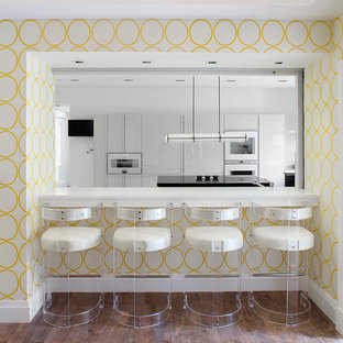 This is an example of a contemporary kitchen in New York with flat-panel cabinets, white cabinets and white appliances.