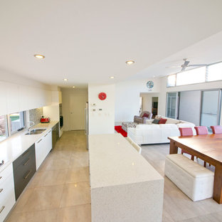 This is an example of a contemporary galley kitchen in Brisbane with glass tile splashback, stainless steel appliances, porcelain floors and recycled glass benchtops.