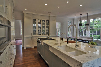 Example of a large trendy single-wall medium tone wood floor and brown floor eat-in kitchen design in Atlanta with a double-bowl sink, flat-panel cabinets, white cabinets, marble countertops, stainless steel appliances and an island
