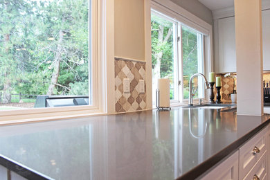 Example of a large trendy u-shaped medium tone wood floor eat-in kitchen design in Denver with an undermount sink, white cabinets, quartzite countertops, stainless steel appliances and an island
