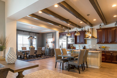 Large transitional medium tone wood floor open concept kitchen photo in Denver with raised-panel cabinets, dark wood cabinets, granite countertops, white backsplash, an island, an undermount sink, subway tile backsplash and stainless steel appliances