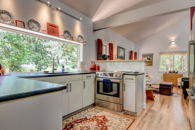 Example of a mid-sized classic u-shaped light wood floor eat-in kitchen design in Other with an undermount sink, white cabinets, white backsplash, stainless steel appliances and no island