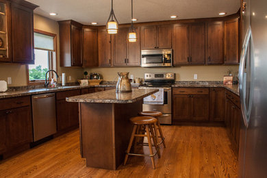 Kitchen - mid-sized craftsman u-shaped medium tone wood floor kitchen idea in Other with an island, an undermount sink, recessed-panel cabinets, medium tone wood cabinets and stainless steel appliances