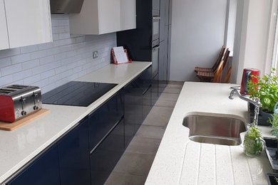 Inspiration for a medium sized galley kitchen in Devon with flat-panel cabinets, blue cabinets, quartz worktops and white worktops.