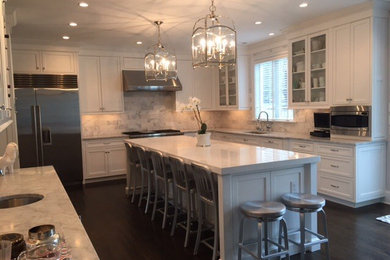 Mid-sized elegant l-shaped dark wood floor eat-in kitchen photo in Philadelphia with an undermount sink, recessed-panel cabinets, white cabinets, marble countertops, gray backsplash, stone tile backsplash, stainless steel appliances and an island