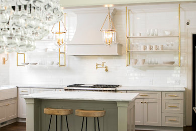 Inspiration for a transitional medium tone wood floor kitchen remodel in Atlanta with a farmhouse sink, shaker cabinets, marble countertops, white backsplash, subway tile backsplash, stainless steel appliances, an island and white countertops
