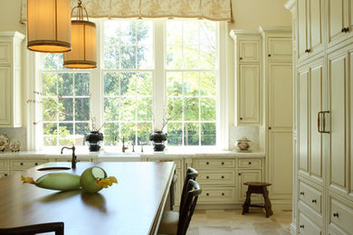 Example of a classic kitchen design in Atlanta with a farmhouse sink, raised-panel cabinets, white cabinets, white backsplash and marble countertops