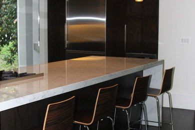 Example of a mid-sized transitional u-shaped dark wood floor eat-in kitchen design in Atlanta with a triple-bowl sink, flat-panel cabinets, dark wood cabinets, marble countertops, white backsplash, stone slab backsplash, stainless steel appliances and a peninsula