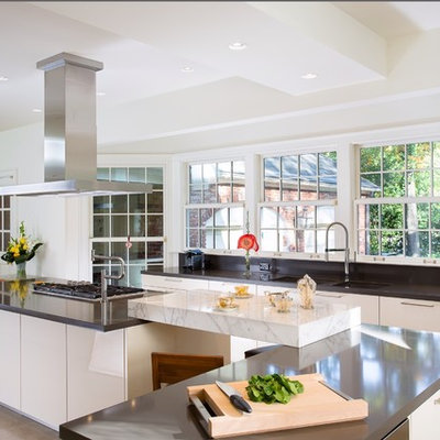 Enclosed kitchen - huge contemporary l-shaped travertine floor enclosed kitchen idea in Atlanta with a double-bowl sink, flat-panel cabinets, beige cabinets, quartz countertops, two islands and stainless steel appliances