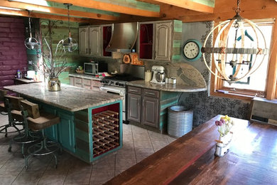 Eat-in kitchen - large rustic galley porcelain tile and beige floor eat-in kitchen idea in Albuquerque with an undermount sink, raised-panel cabinets, distressed cabinets, granite countertops, beige backsplash, stone slab backsplash, stainless steel appliances, an island and beige countertops