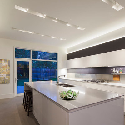 Trendy kitchen photo in Chicago with a double-bowl sink, flat-panel cabinets, white cabinets, white backsplash and stainless steel appliances