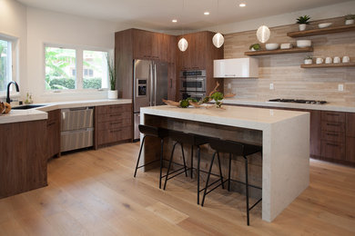 Large trendy u-shaped light wood floor open concept kitchen photo in Orange County with an undermount sink, flat-panel cabinets, dark wood cabinets, marble countertops, beige backsplash, matchstick tile backsplash, stainless steel appliances and an island
