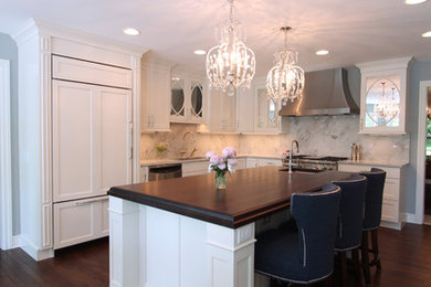Mid-sized transitional l-shaped dark wood floor eat-in kitchen photo in Other with a double-bowl sink, recessed-panel cabinets, white cabinets, stone slab backsplash, stainless steel appliances, an island, quartzite countertops and white backsplash