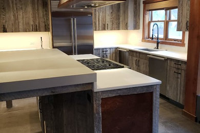 Kitchen - large farmhouse kitchen idea in Milwaukee with distressed cabinets, concrete countertops, stainless steel appliances and gray countertops