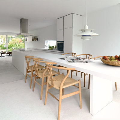 Mid-sized trendy galley concrete floor open concept kitchen photo in Melbourne with an undermount sink, flat-panel cabinets, white cabinets, stainless steel appliances, an island and white backsplash