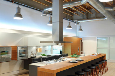 Open concept kitchen - huge contemporary galley light wood floor open concept kitchen idea in Los Angeles with an integrated sink, flat-panel cabinets, medium tone wood cabinets, stainless steel countertops, metallic backsplash, stainless steel appliances and an island