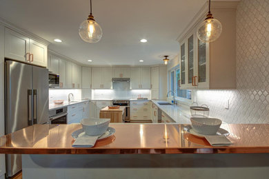Example of a mid-sized minimalist kitchen design in Seattle with an undermount sink, white cabinets, copper countertops, white backsplash and stainless steel appliances