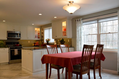 Example of a mid-sized classic u-shaped marble floor eat-in kitchen design in Boston with a double-bowl sink, recessed-panel cabinets, white cabinets, granite countertops, green backsplash, glass tile backsplash and stainless steel appliances