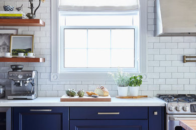 トロントにある高級な中くらいなトラディショナルスタイルのおしゃれなキッチン (エプロンフロントシンク、青いキャビネット、珪岩カウンター、白いキッチンパネル、無垢フローリング、白いキッチンカウンター) の写真