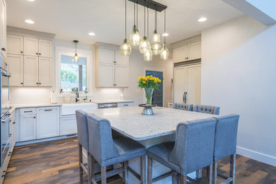 Eat-in kitchen - large transitional u-shaped medium tone wood floor and brown floor eat-in kitchen idea in Other with a farmhouse sink, shaker cabinets, white cabinets, quartz countertops, stainless steel appliances, an island and white countertops