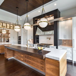 Foto de cocina moderna, grande, con fregadero sobremueble, armarios con paneles empotrados, puertas de armario blancas, encimera de azulejos, salpicadero metalizado, salpicadero de metal, electrodomésticos blancos, suelo de madera oscura, dos o más islas, suelo marrón y encimeras blancas