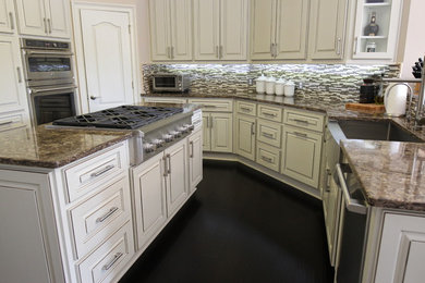 Inspiration for a large timeless u-shaped dark wood floor and brown floor enclosed kitchen remodel in Jacksonville with a farmhouse sink, raised-panel cabinets, white cabinets, quartzite countertops, multicolored backsplash, matchstick tile backsplash, stainless steel appliances, an island and beige countertops