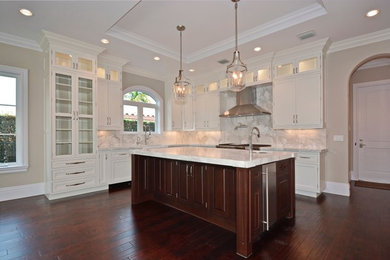 Eat-in kitchen - large transitional u-shaped dark wood floor and brown floor eat-in kitchen idea in Miami with shaker cabinets, white cabinets, quartz countertops, paneled appliances, an island, a farmhouse sink, white backsplash and stone slab backsplash