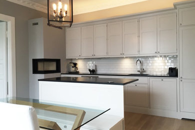 Mid-sized elegant single-wall eat-in kitchen photo in Other with shaker cabinets and an island