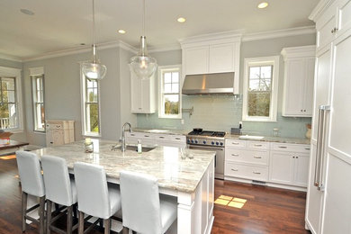 Large transitional l-shaped medium tone wood floor and brown floor eat-in kitchen photo in Wilmington with an undermount sink, shaker cabinets, white cabinets, marble countertops, green backsplash, subway tile backsplash, stainless steel appliances and an island